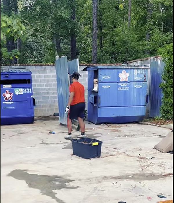 Crew member clearing debris around the dumpsters